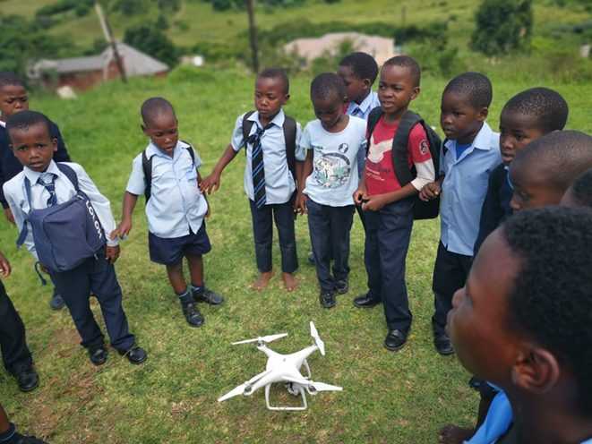 children around a drone